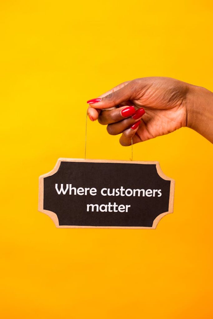 Mastering the First Impression: Your intriguing post title goes here Hand holding a sign with 'Where customers matter' on a vibrant yellow backdrop.